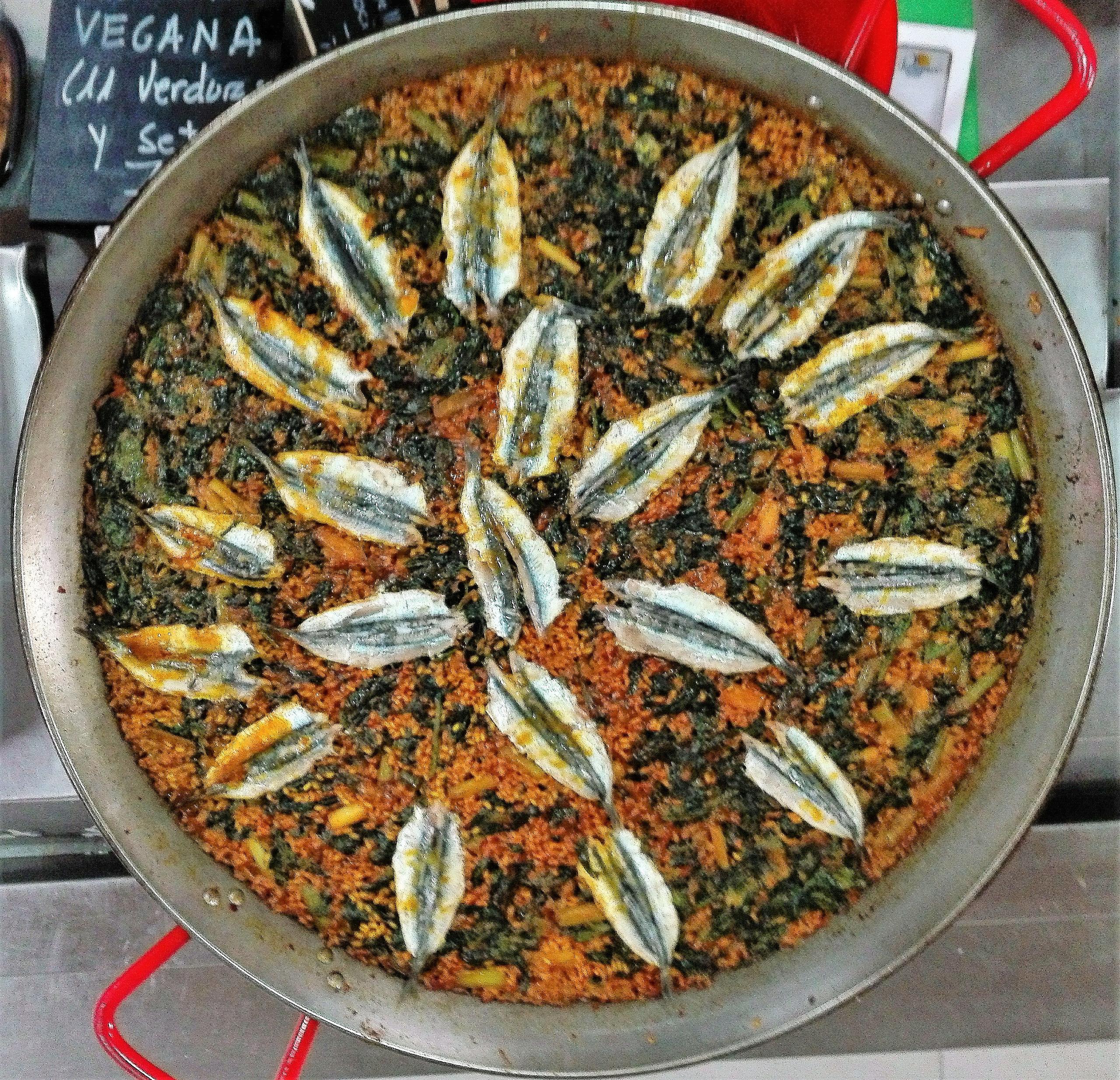 Paella with anchovies, spinach and garlic